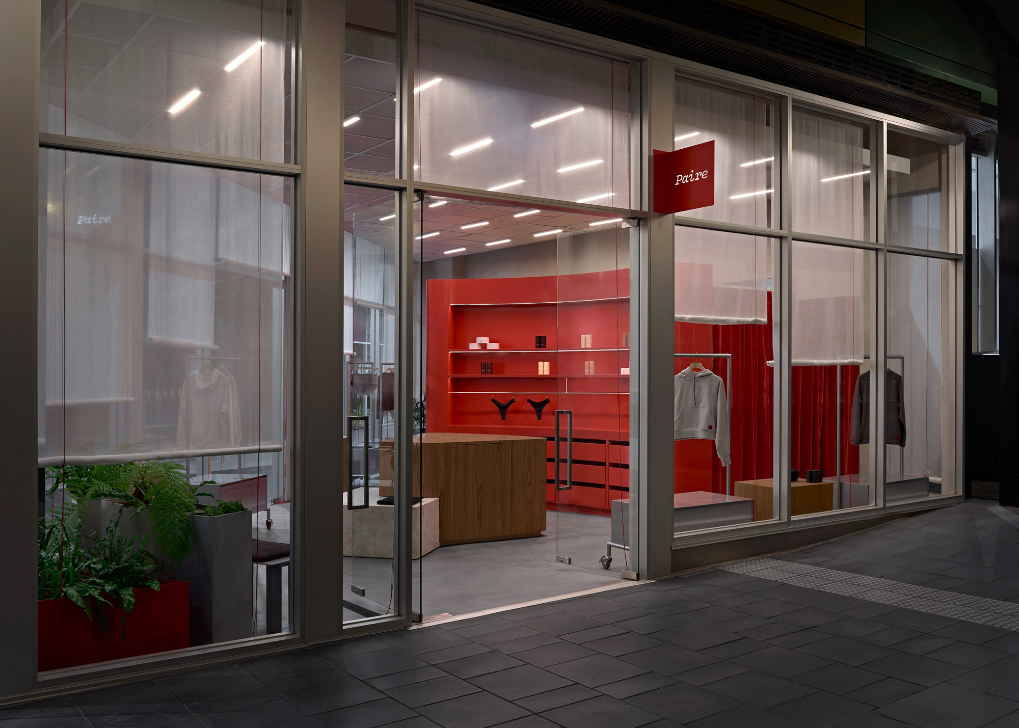 Paire QV shopfront at night with red lacquer interior and illuminated blade signage