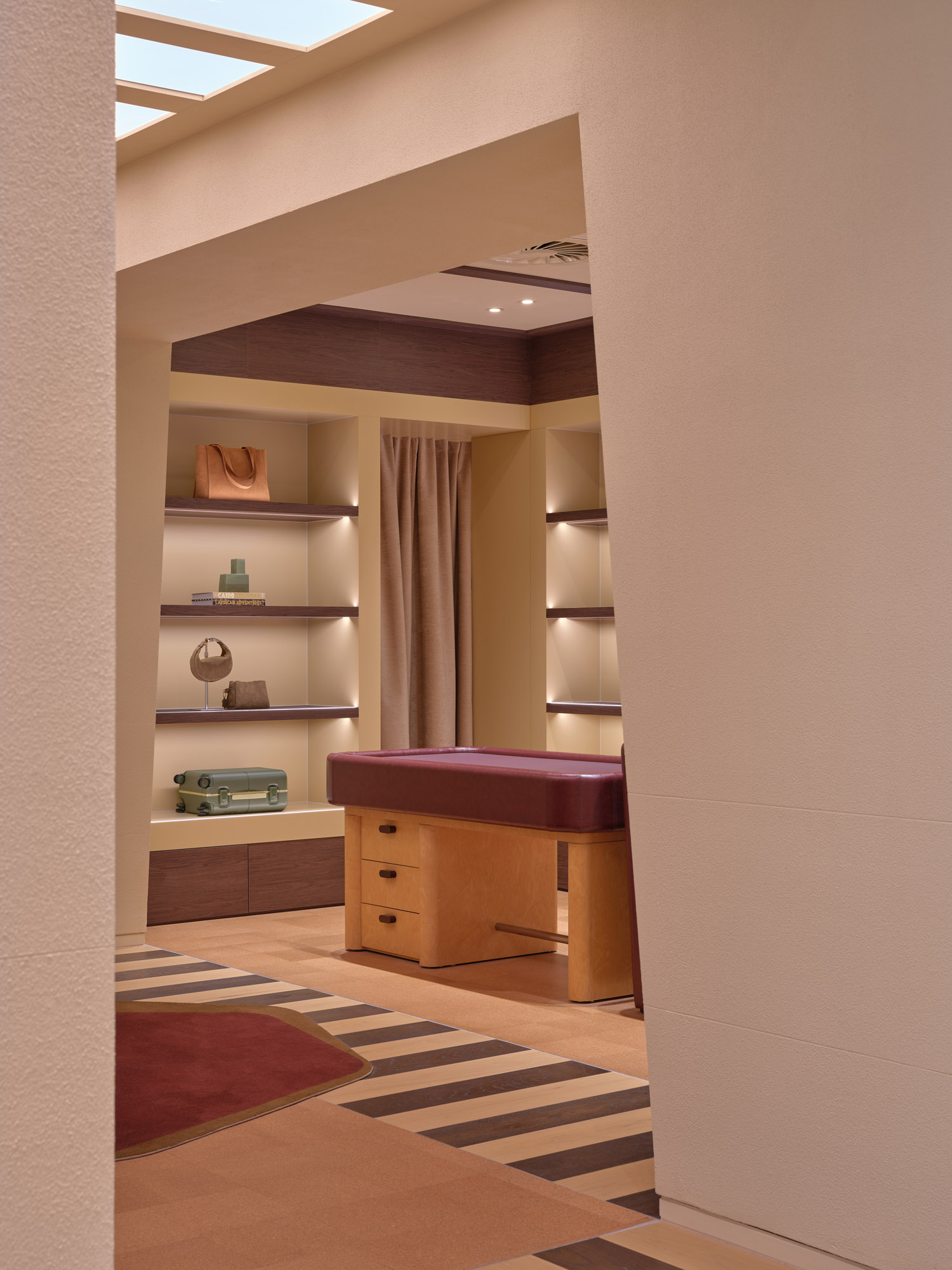 View through portal to curtained fitting room and lit shelving niches