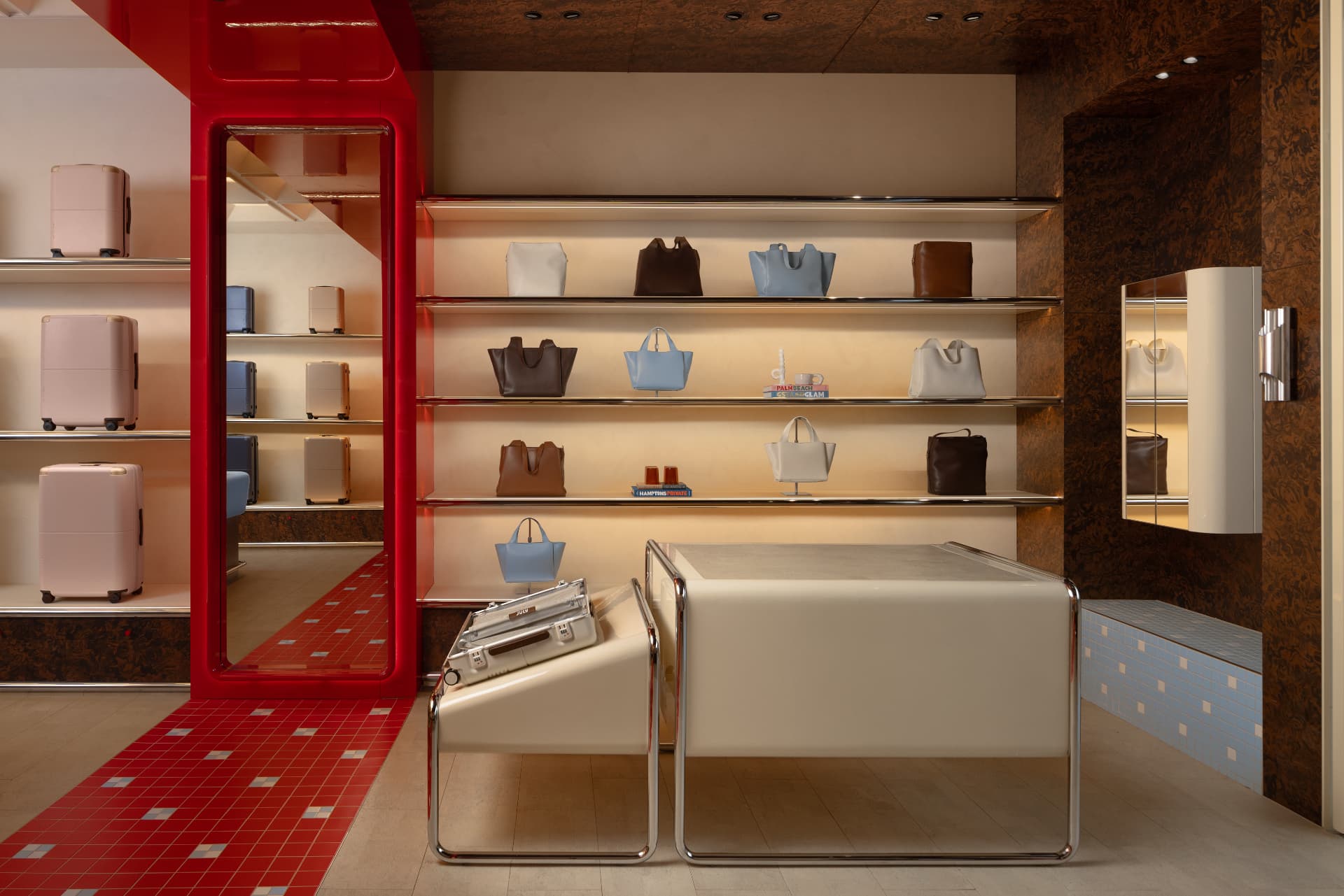 Backlit stainless shelving with bags and chrome-framed display plinths