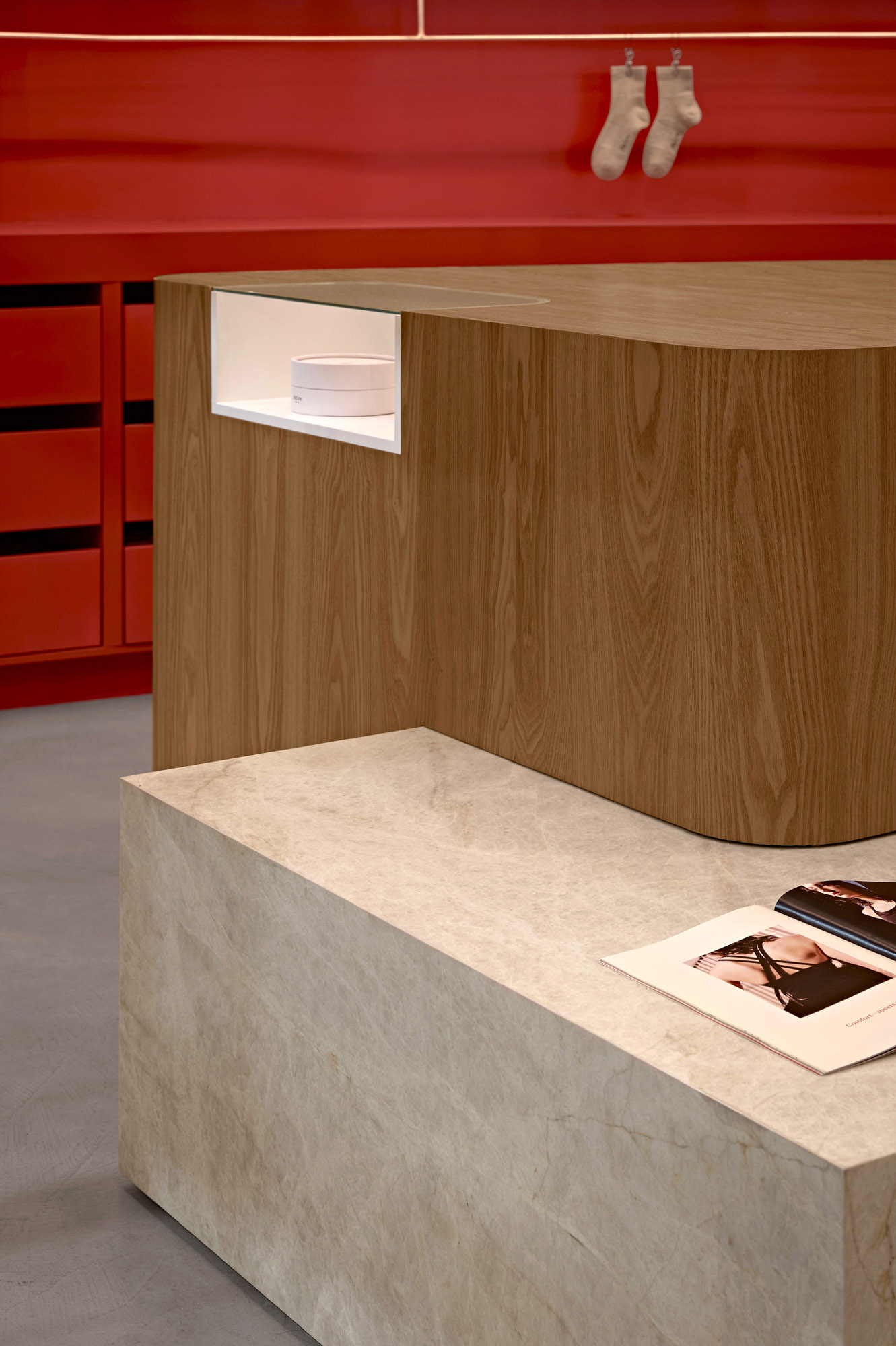 Oak cash wrap with recessed vitrine beside a stone plinth